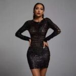 Woman wearing a black cutout bodycon dress against a grey background